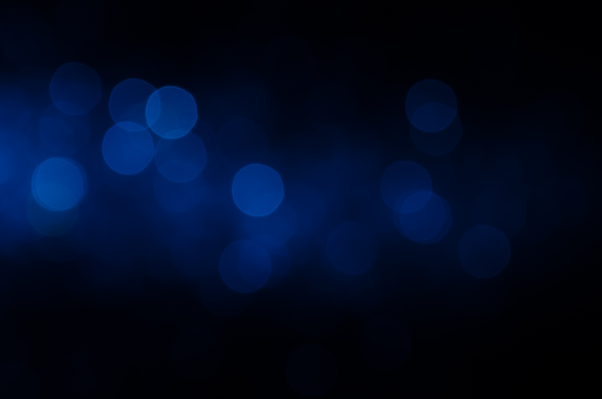 Dark blue abstract bokeh background.